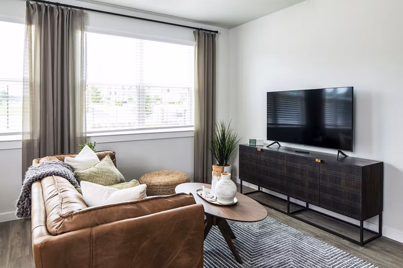 Modern living room featuring brown leather sofa and decorative plants in luxury apartment