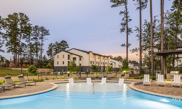 â€œLuxury swimming pool area with lounge chairs and trees at upscale apartmentsâ€
