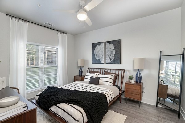 Spacious bedroom with modern furniture and ambient lighting at The Avante Apartments