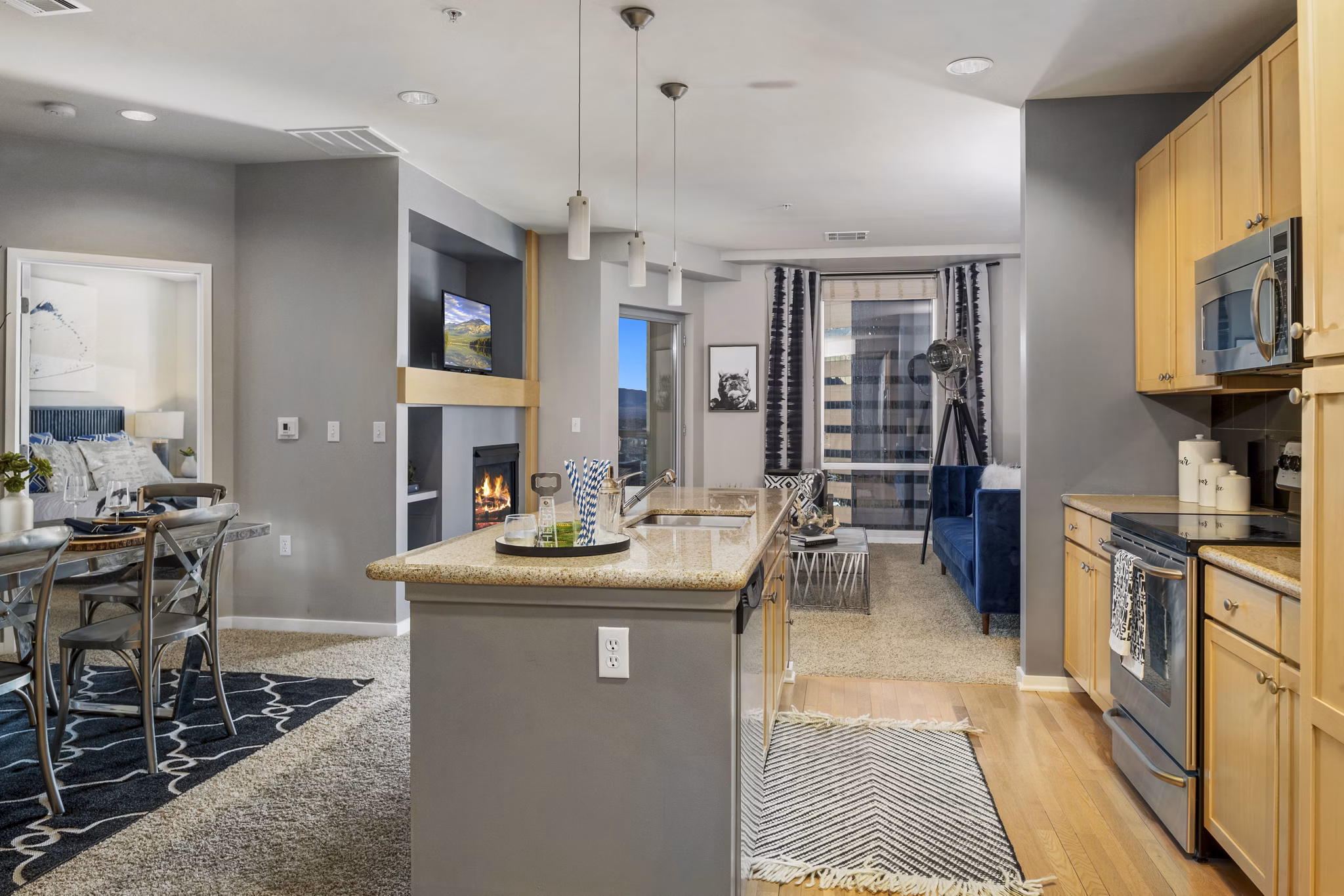 Modern kitchen with stainless steel appliances and marble countertops at 1600 Glenarm Place Apartments