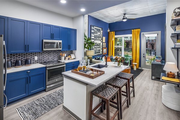 Modern kitchen featuring stainless steel appliances and sleek cabinetry in Beckon Apartments