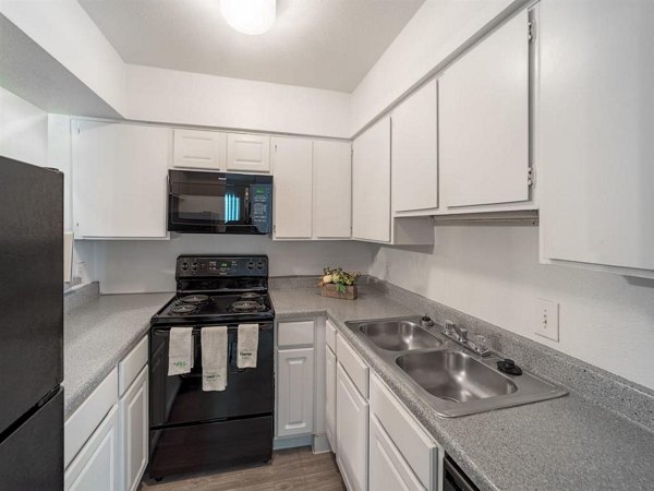 Modern kitchen with stainless steel appliances and granite countertops at Carelton Courtyard apartments