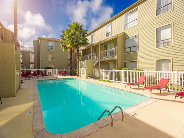 Relaxing outdoor pool with lounge chairs at Carelton Courtyard Apartments