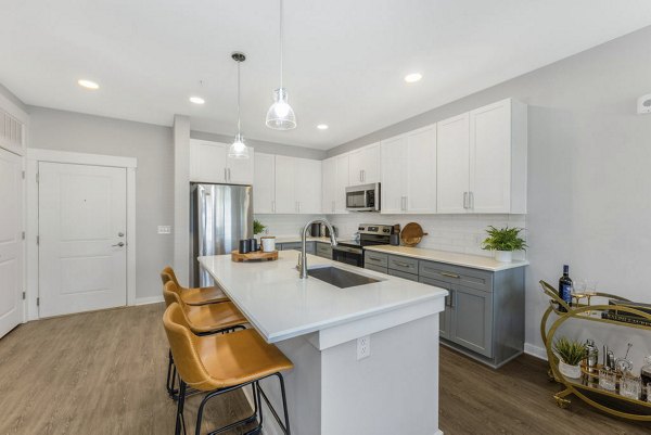 Modern kitchen with stainless steel appliances and granite countertops in Indigo at Berewick Apartments