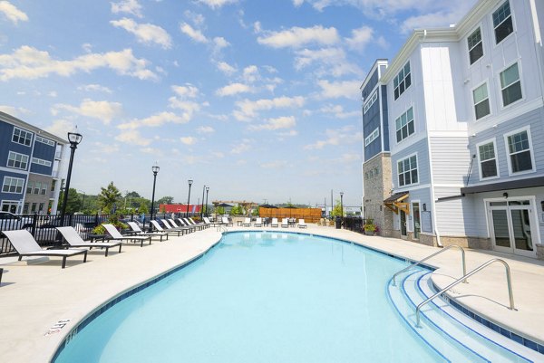 Resort-style pool with lounge chairs and landscaped surroundings at Indigo at Berewick Apartments, perfect for relaxation and leisure