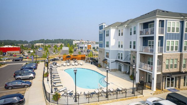 Resort-style pool with lounge chairs at Indigo at Berewick Apartments, perfect for relaxation and leisure activities