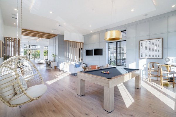 Game room with pool table and lounge seating at Citizen House MLK Apartments