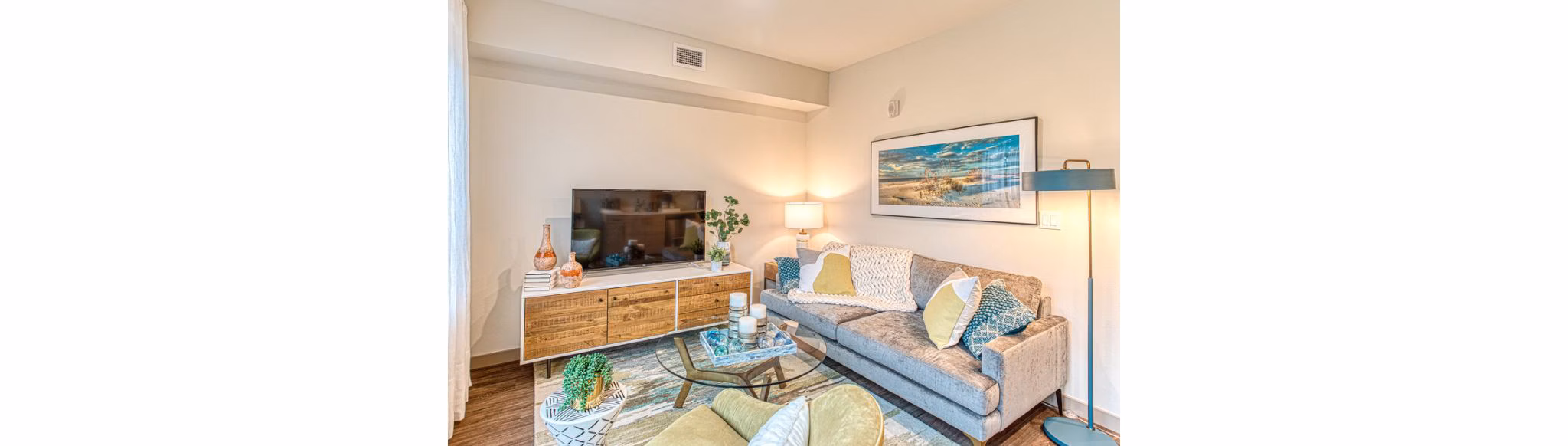 Spacious living room with modern furniture and large windows in Ethos Apartments