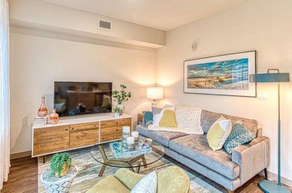 Spacious living room with modern furniture and large windows in Ethos Apartments