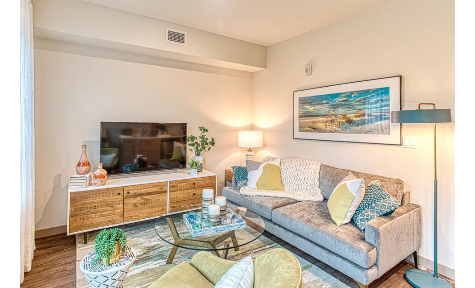 Spacious living room with modern furniture and large windows in Ethos Apartments