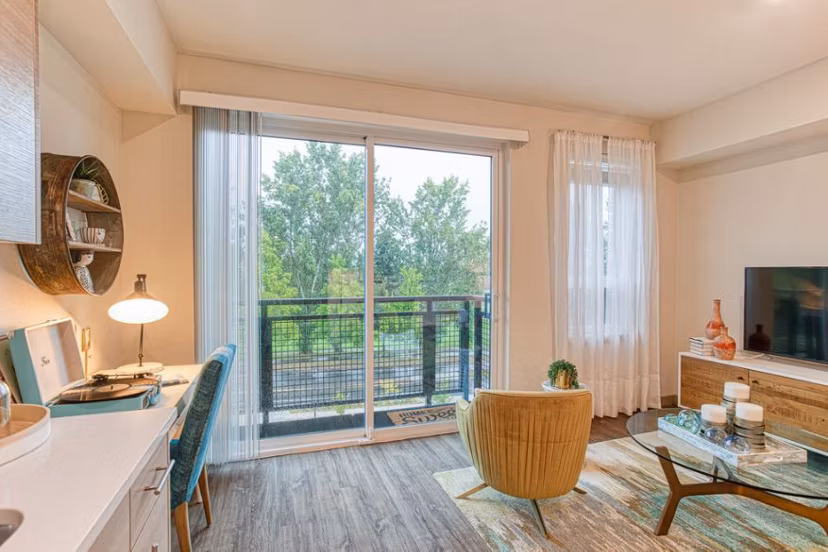 Bright living room with modern furnishings and large windows at Ethos Apartments in vibrant city setting