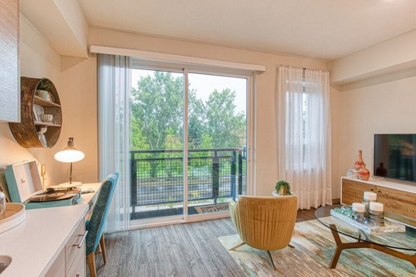 Bright living room with modern furnishings and large windows at Ethos Apartments in vibrant city setting