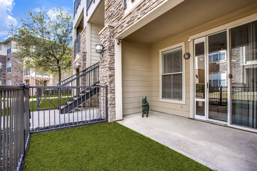 Cozy patio at Equinox on the Park Apartments featuring outdoor seating and greenery