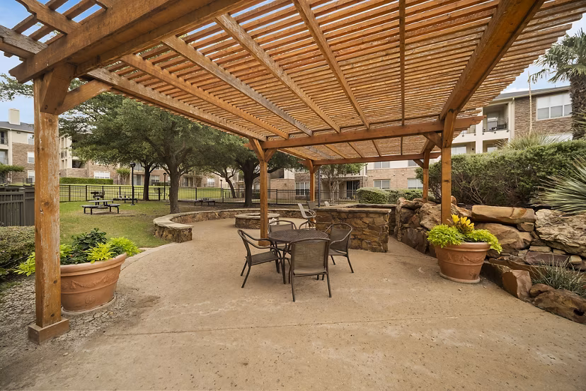 Serene patio with lush greenery at Equinox on the Park Apartments, perfect for outdoor relaxation and gatherings in a luxury setting