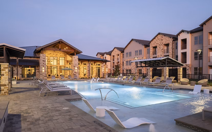 Modern poolside leisure area at Broadstone Cross Creek Ranch Apartments with luxury seating and lush landscaping
