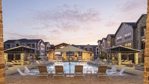 Tranquil outdoor pool at Broadstone Cross Creek Ranch Apartments featuring lounge chairs, surrounded by lush greenery perfect for relaxation