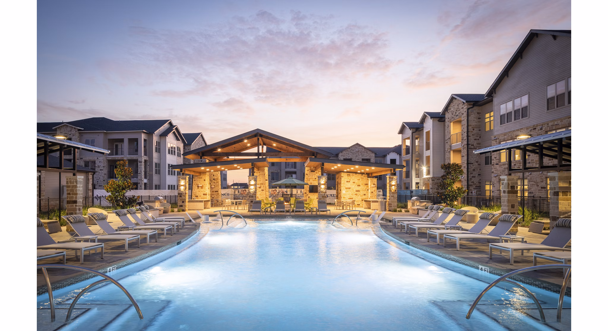 Luxurious swimming pool area with lounge chairs and pavilion at luxury apartments