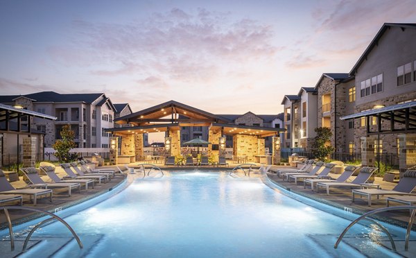 Luxurious swimming pool area with lounge chairs and pavilion at luxury apartments