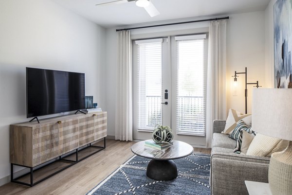 Modern living room with plush seating and large windows in Broadstone Jordan Ranch Apartments