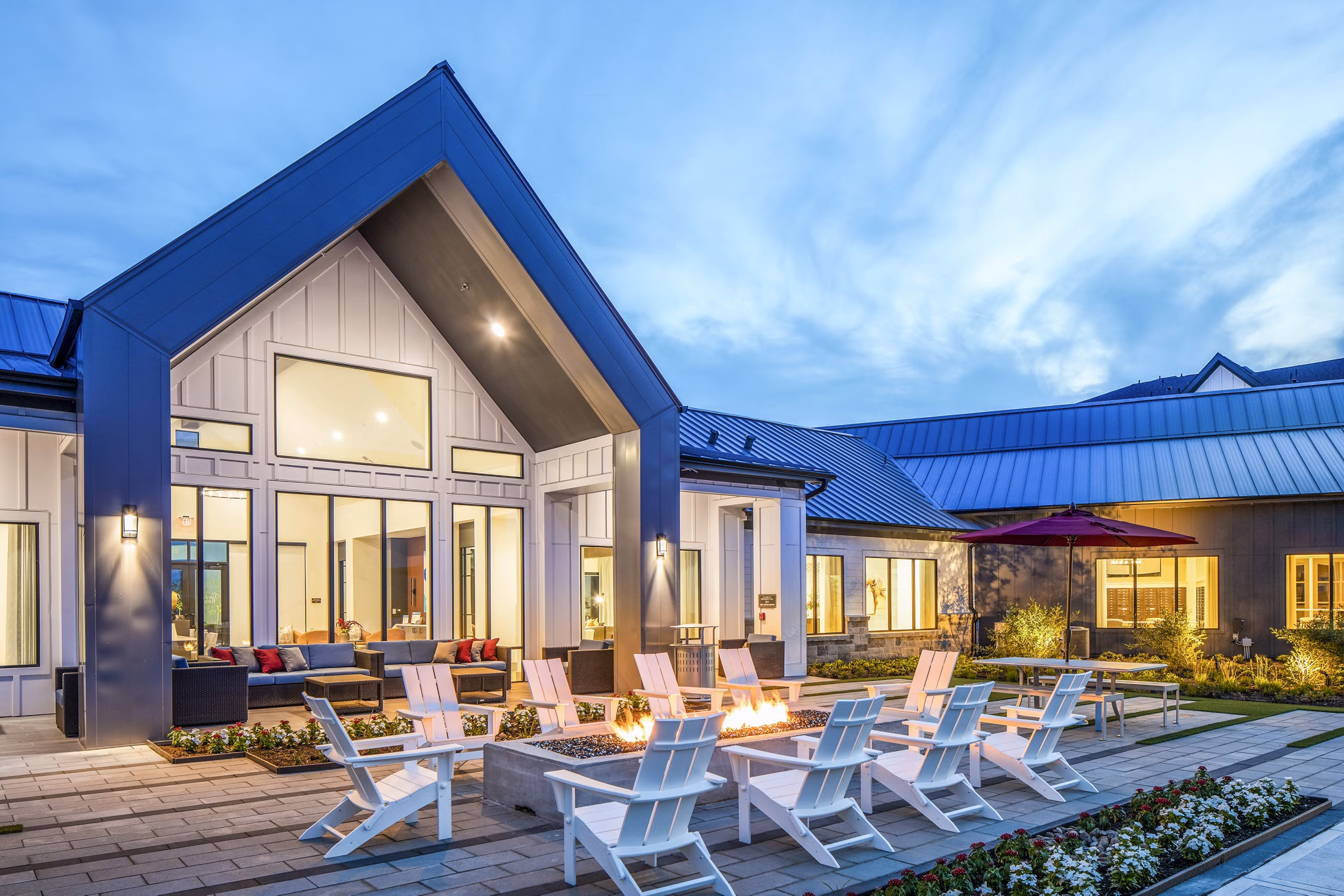 Modern luxury apartment patio with outdoor seating and a fire pit in a serene environment
