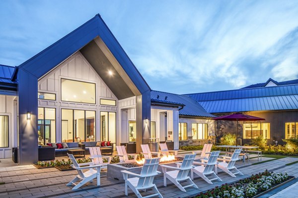 Modern luxury apartment patio with outdoor seating and a fire pit in a serene environment