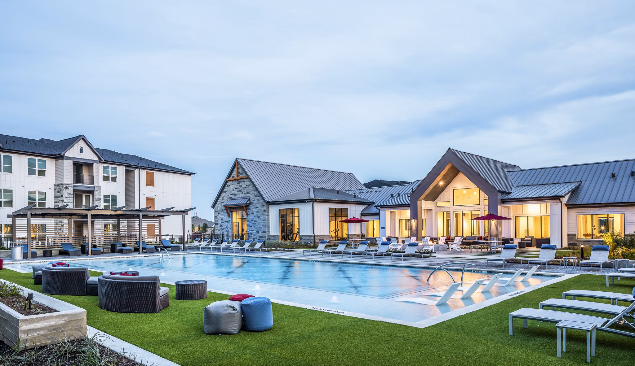 Luxury apartments with a swimming pool and outdoor lounge areas in a modern residential complex
