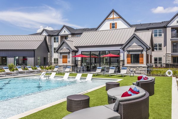 Modern luxury apartment complex featuring a swimming pool and outdoor lounge seating