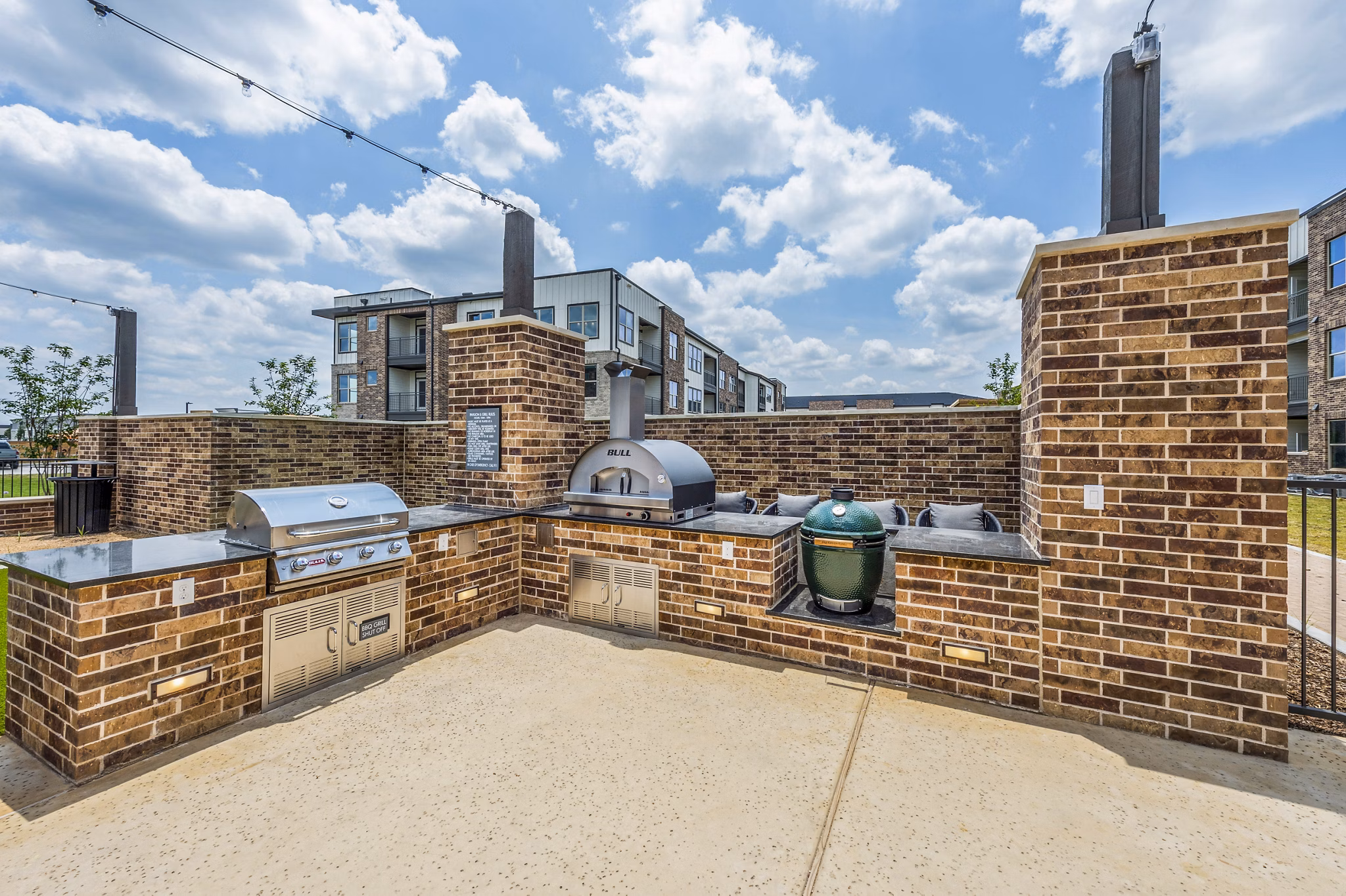 Outdoor grill area with modern seating at Lenox Grand West Apartments