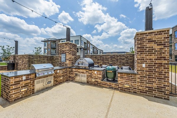Outdoor grill area with modern seating at Lenox Grand West Apartments
