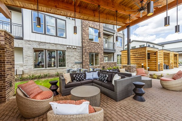 Relaxing pool and patio area with lounge chairs at Lenox Grand West Apartments, ideal for socializing and enjoying the outdoors