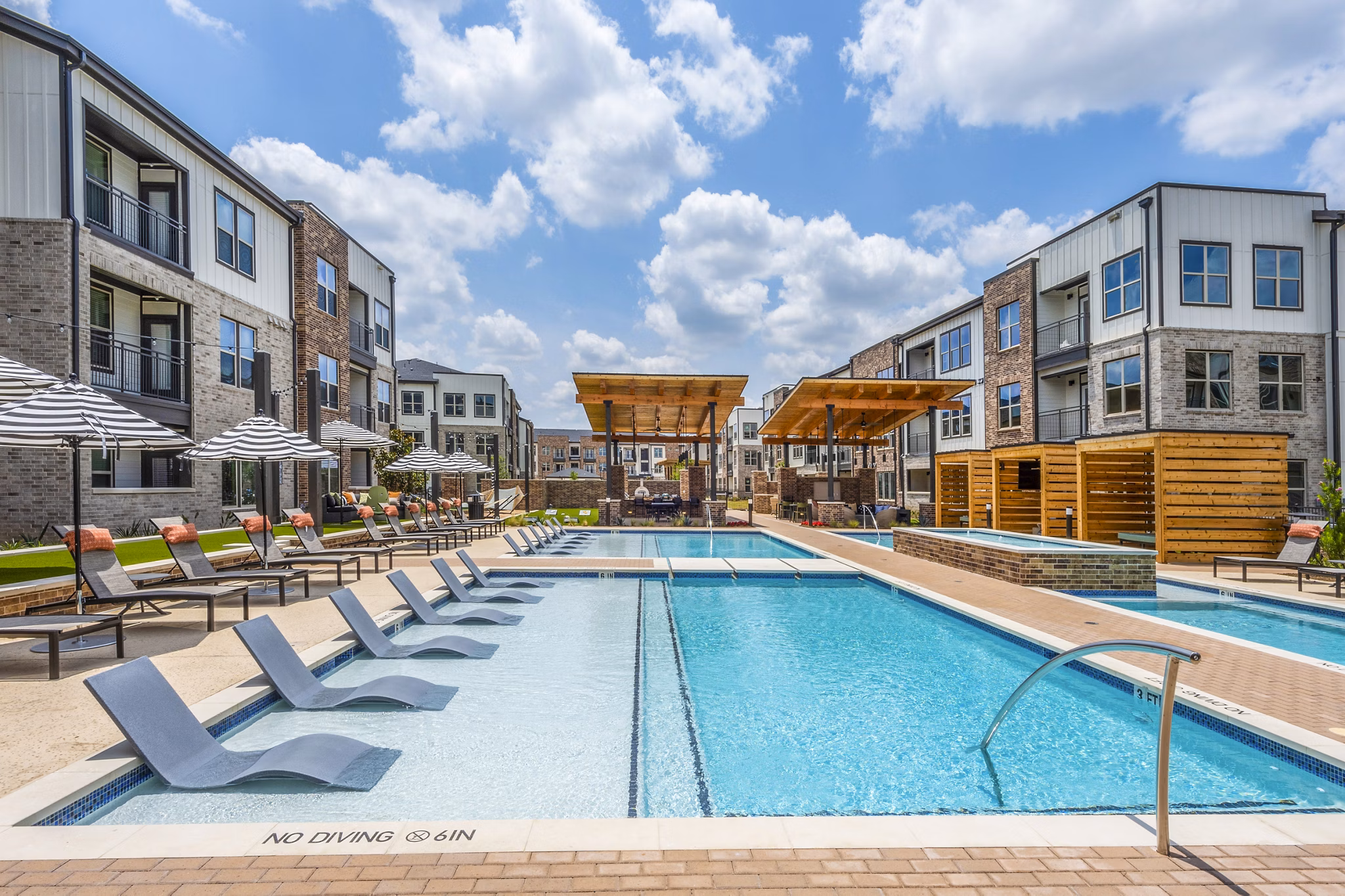 Luxurious pool area with loungers and greenery at Lenox Grand West Apartments, ideal for relaxing or socializing