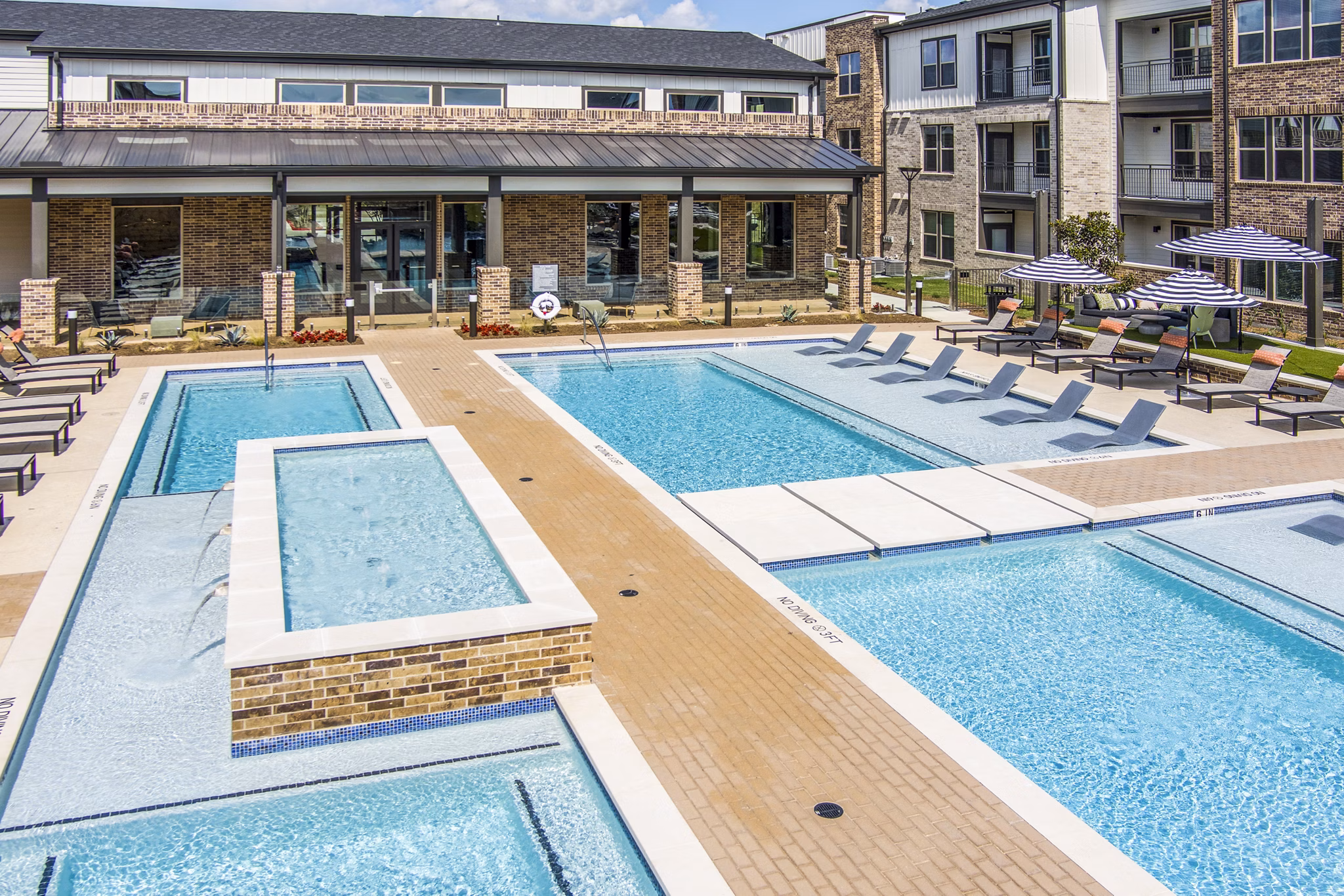 Resort-style swimming pool at Lenox Grand West Apartments with sun loungers and landscaped surroundings