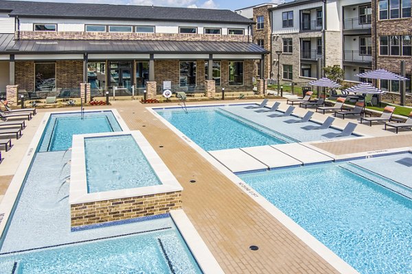 Resort-style swimming pool at Lenox Grand West Apartments with sun loungers and landscaped surroundings