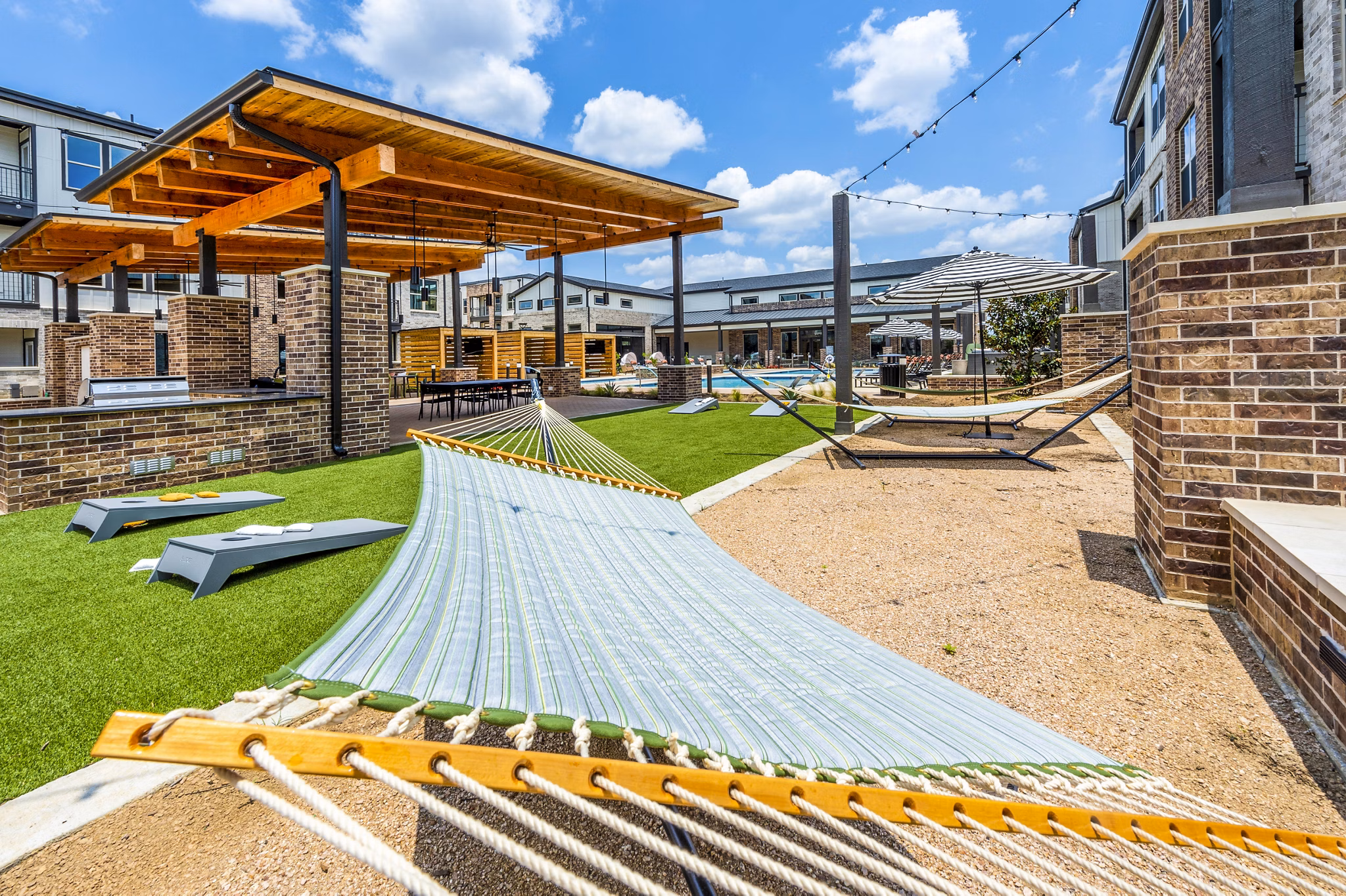 Hammock area with lush greenery at Lenox Grand West Apartments, perfect for relaxation and outdoor leisure activities