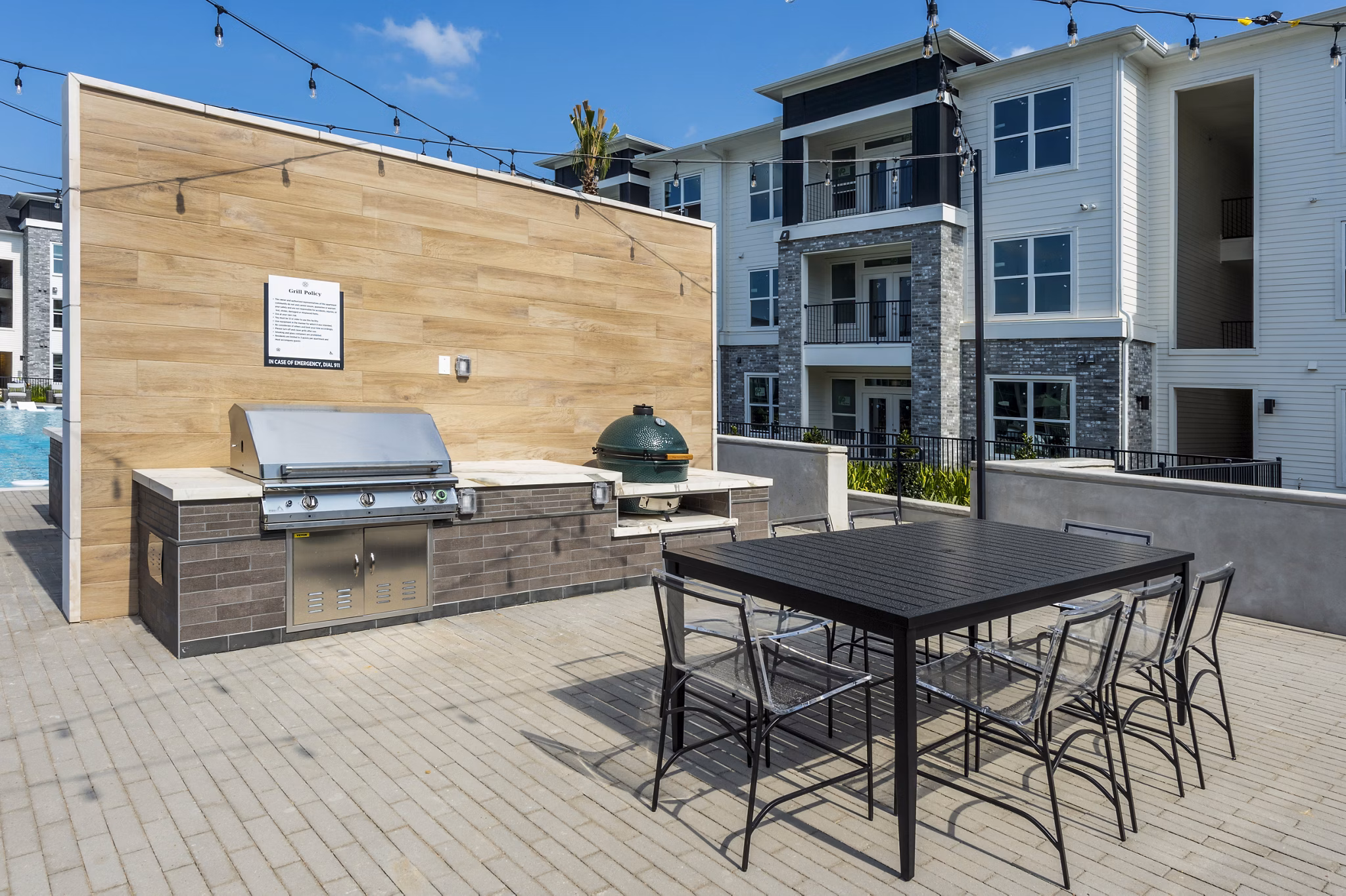 Outdoor grill area with seating at The Madison Apartments, offering modern amenities for luxury living