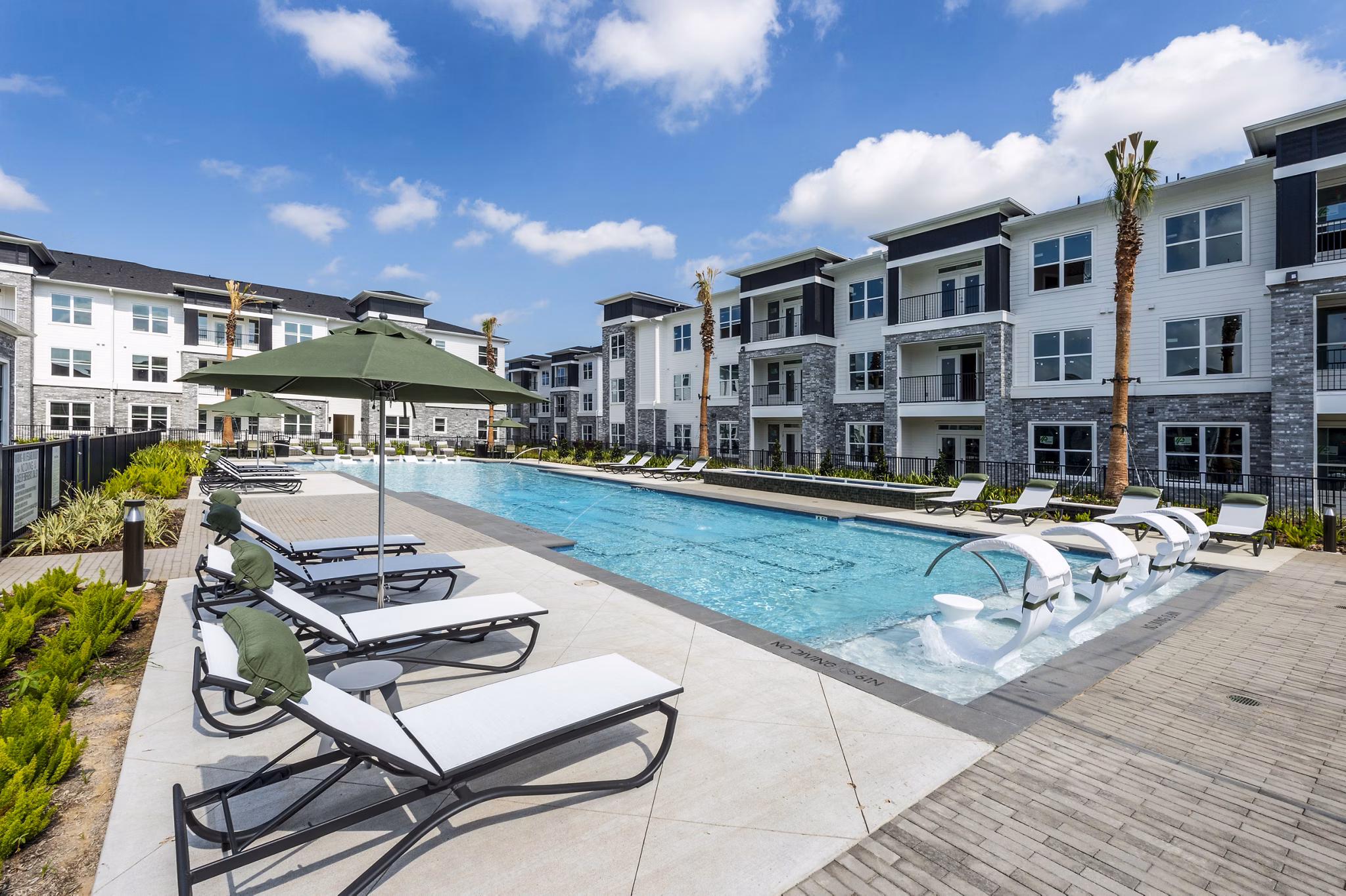 Luxury pool with stylish lounge chairs at The Madison Apartments, a Greystar luxury community in a vibrant urban setting