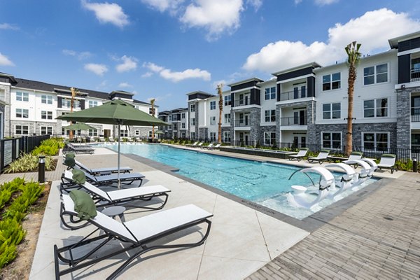 Luxury pool with stylish lounge chairs at The Madison Apartments, a Greystar luxury community in a vibrant urban setting