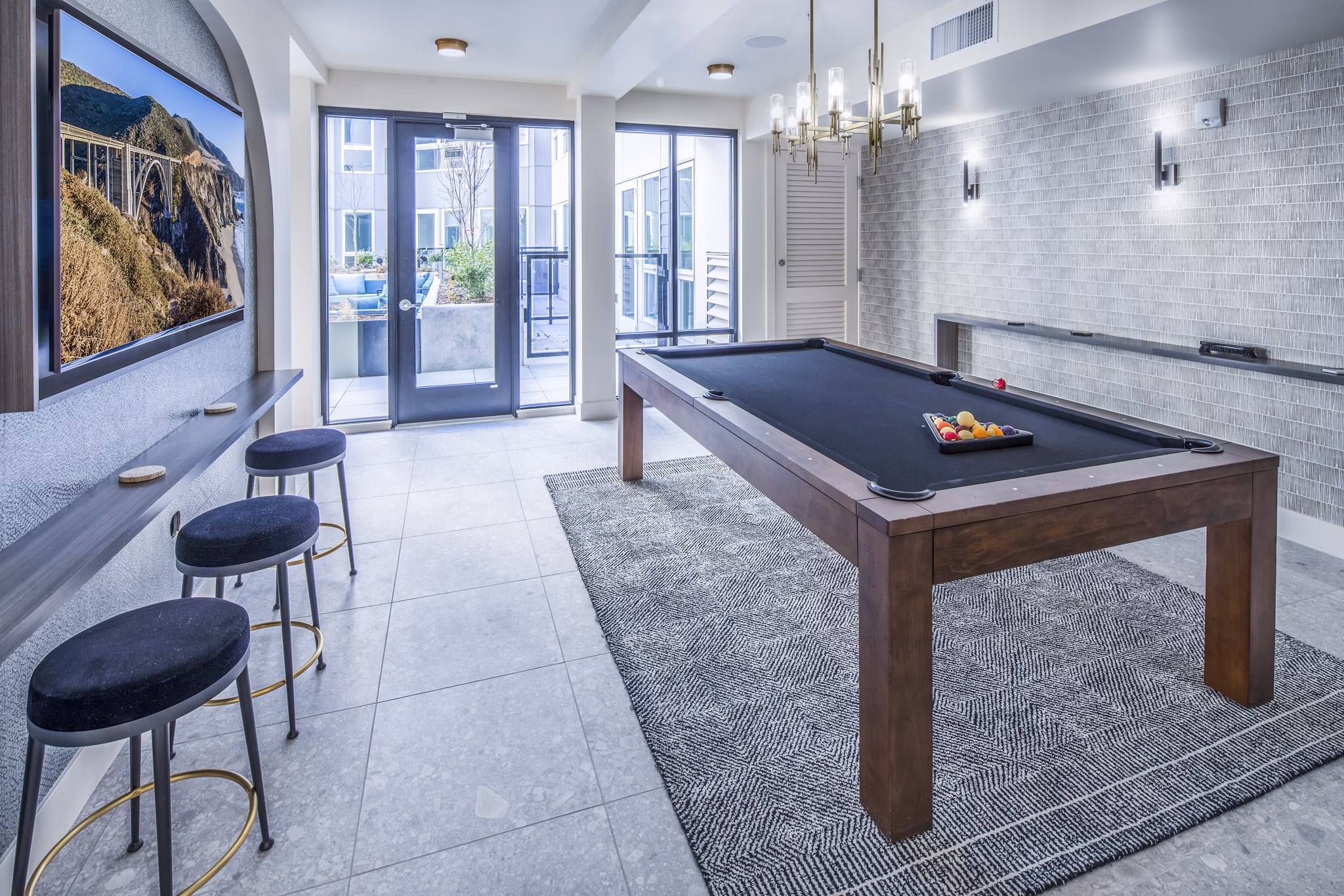 Clubhouse game room with pool table and lounge seating at Broadstone Claro Apartments