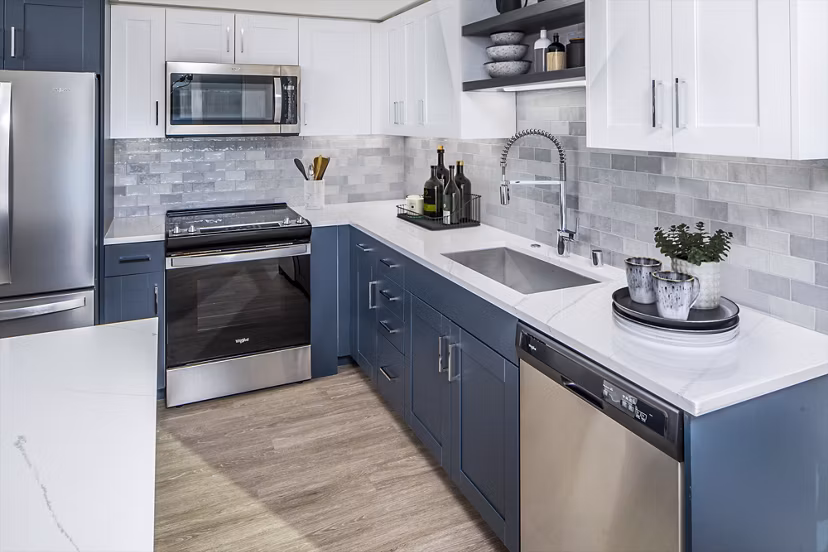 Modern kitchen with stainless steel appliances and marble countertops at Broadstone Claro Apartments