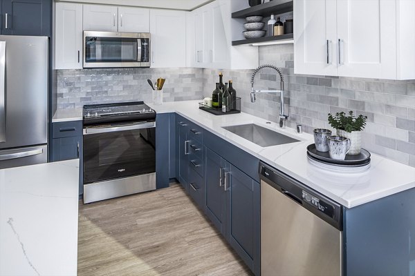 Modern kitchen with stainless steel appliances and marble countertops at Broadstone Claro Apartments