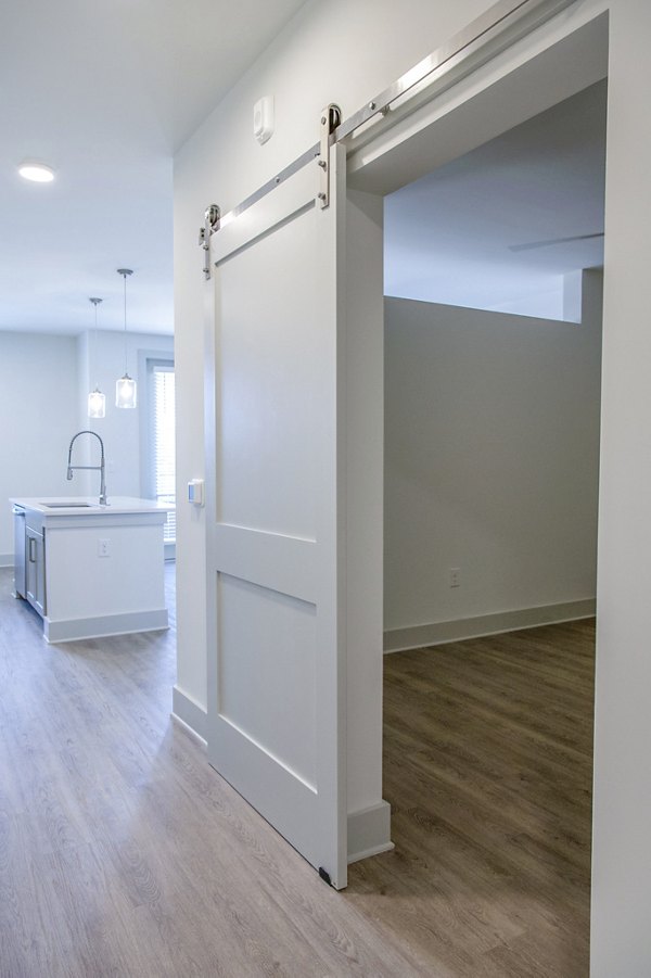 Luxurious bedroom with modern decor at Lakehouse on Wylie Apartments, featuring serene lake views and spacious design