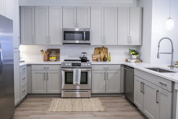 Modern kitchen featuring stainless steel appliances and quartz countertops at Lakehouse on Wylie Apartments