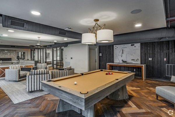 Clubhouse game room with pool table and cozy seating at Atlantic on Romney Apartments