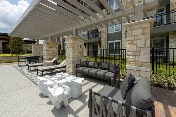 Relaxing patio with lush greenery at Creekside Park The Grove Apartments, a luxury community by Greystar in a serene setting