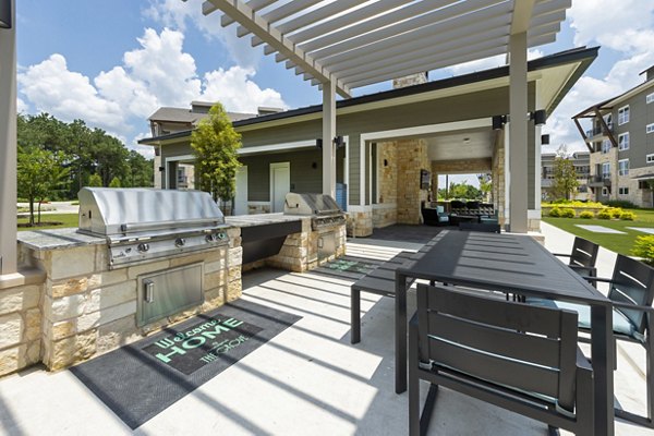 Outdoor grill area with modern seating at Creekside Park The Grove Apartments, ideal for social gatherings and leisure activities