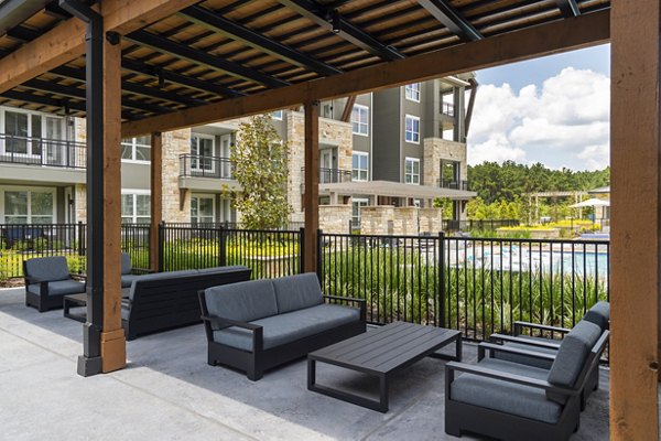 Spacious patio with seating and greenery at Creekside Park The Grove Apartments Perfect outdoor relaxation space in a luxury setting