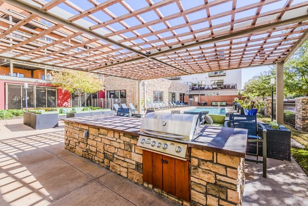 Outdoor grill area with seating at The Dylan Apartments, ideal for entertaining and leisure activities