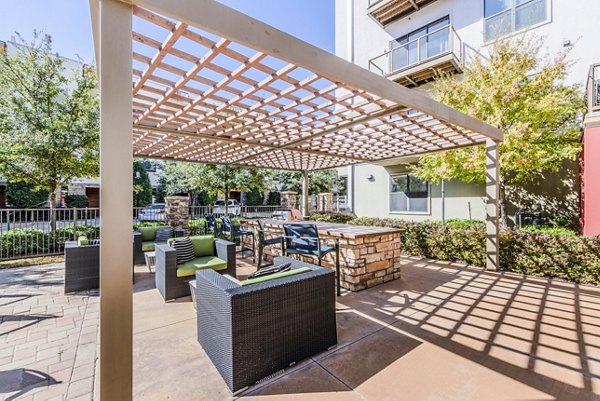 Outdoor grill area and patio with seating at The Dylan Apartments, ideal for summer gatherings and relaxation