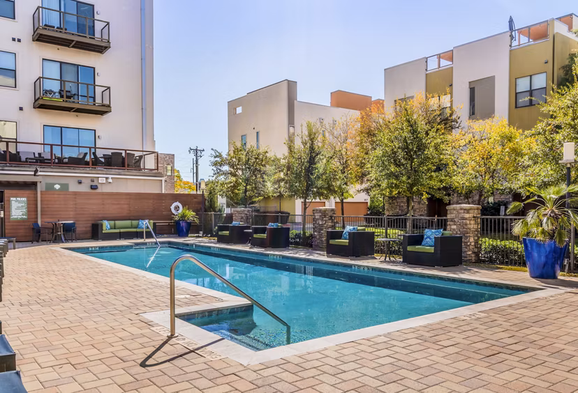 Relaxing poolside retreat at The Dylan Apartments featuring luxury loungers and pristine swimming area