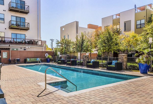 Relaxing poolside retreat at The Dylan Apartments featuring luxury loungers and pristine swimming area